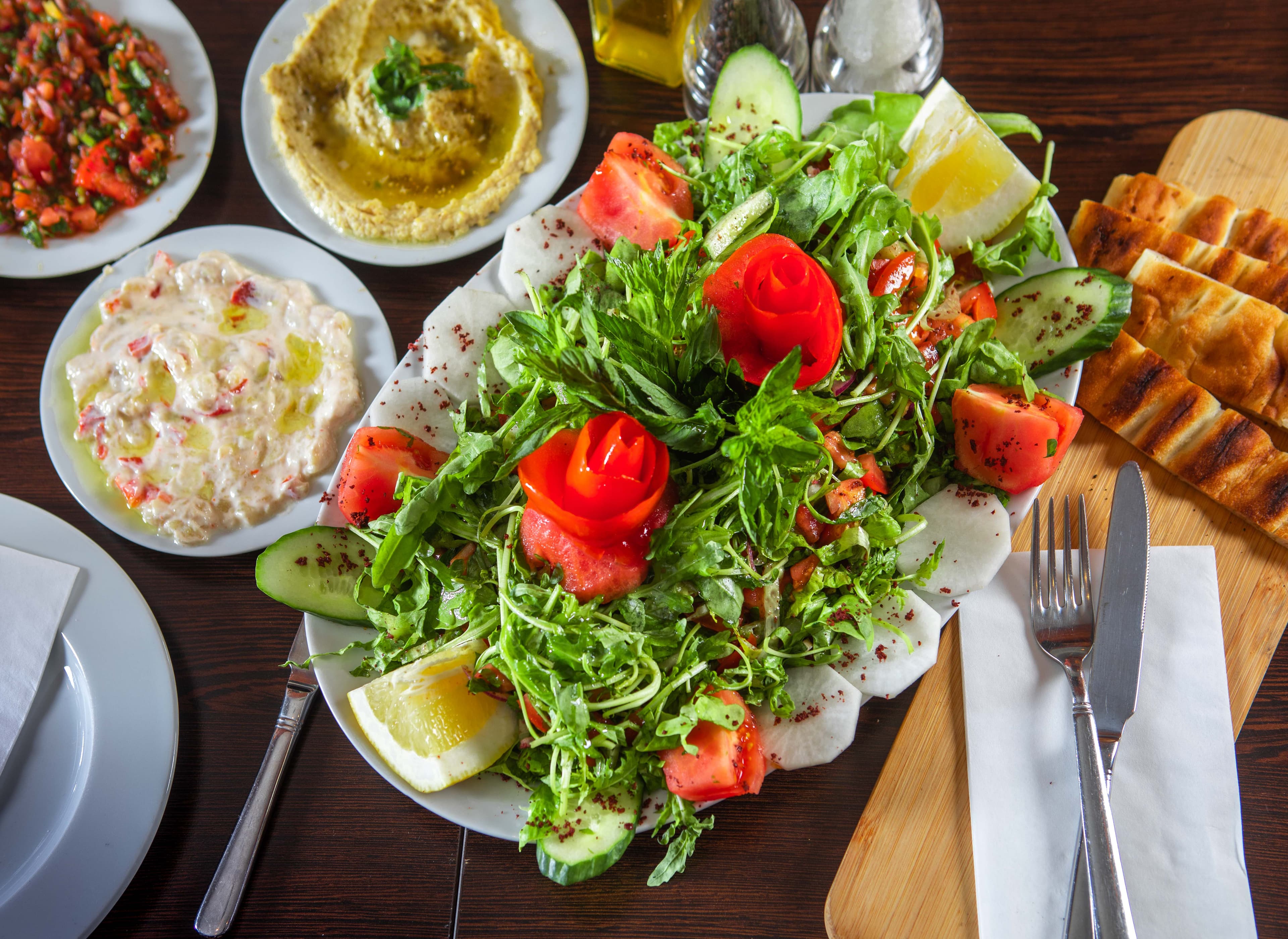 Frischer Salat mit Tomatenrosen, Hummus, Ezme und gegrilltem Fladenbrot
